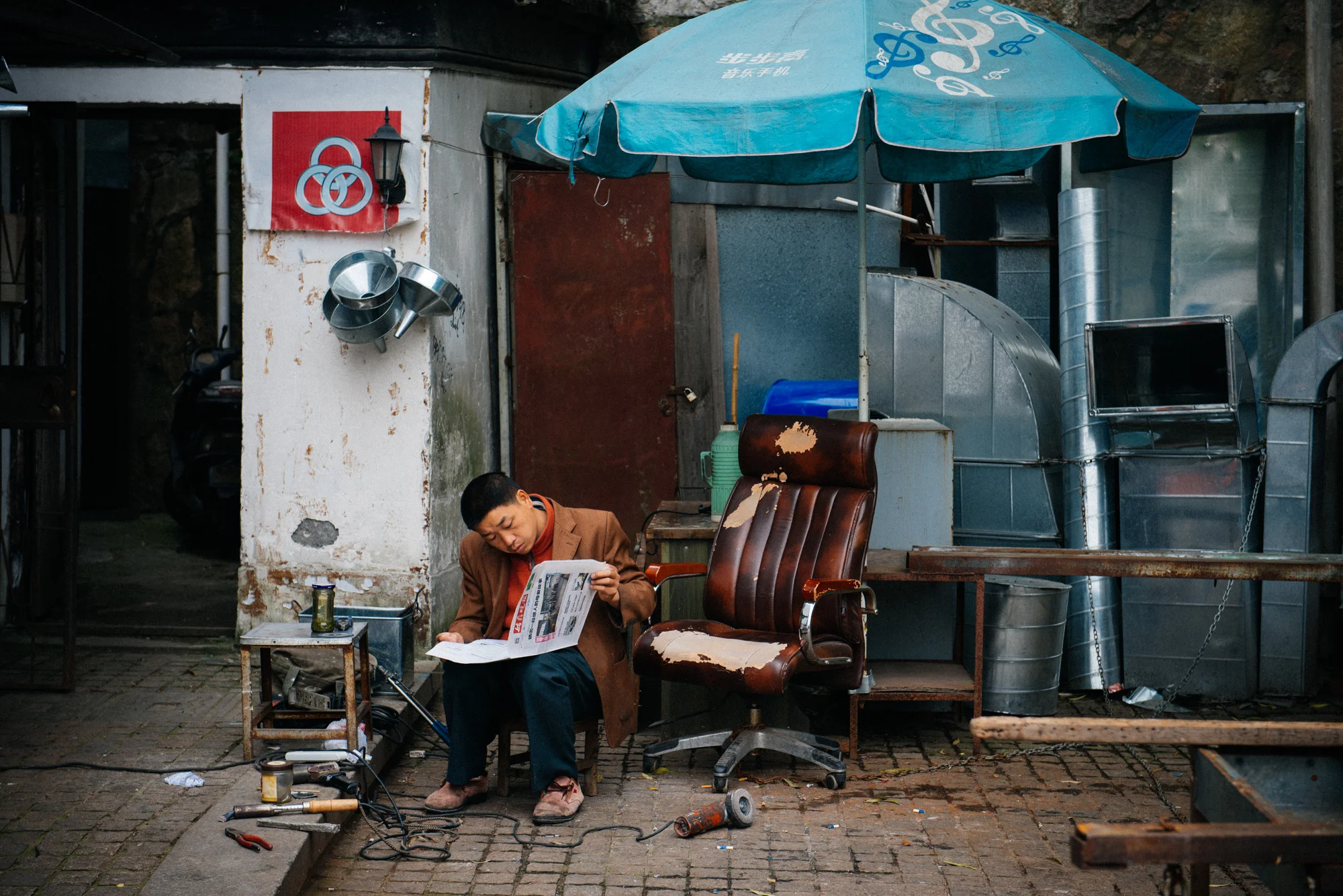 Beside the entrance to the ancient city walls (that apparently were rebuilt only about two years ago), a man reads the paper during a break from work.