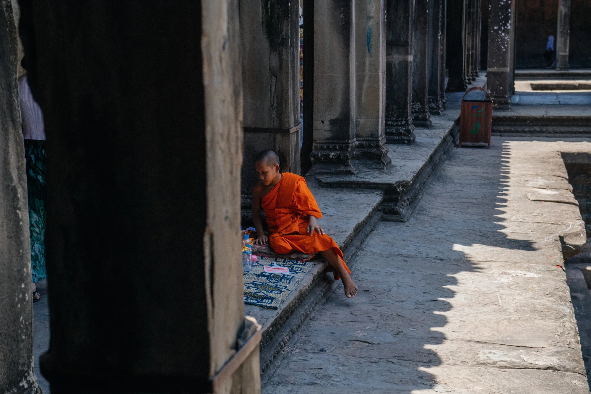 Two young monks rested beside the empty pools at the base of the temple. Many people would stop and donate them money and pray.