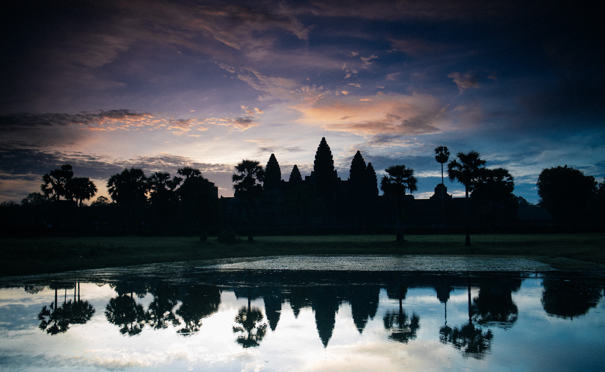 Sun rises behind Angkor Wat, which unusually faces west, on a hot and humid summer day during rainy season. I was very lucky to get a good sunset on that day, as it rained constantly.