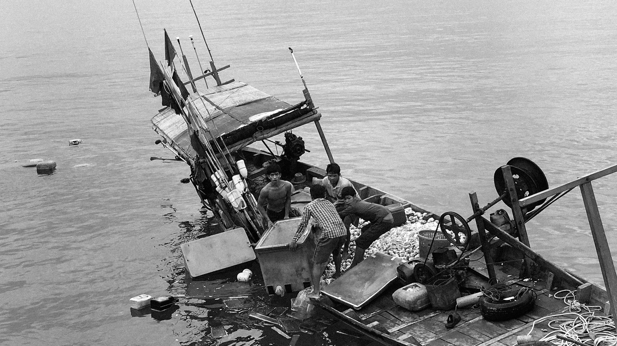 Fishermen desperately hold on to their coolers full of squid that were quickly taken from the sinking boat. Even after such a tragic loss, they were worried about their catch. Every few minutes someone would add sea water to the boxes. They still needed to make a sale that day. That's how they make a living. That's how they eat.