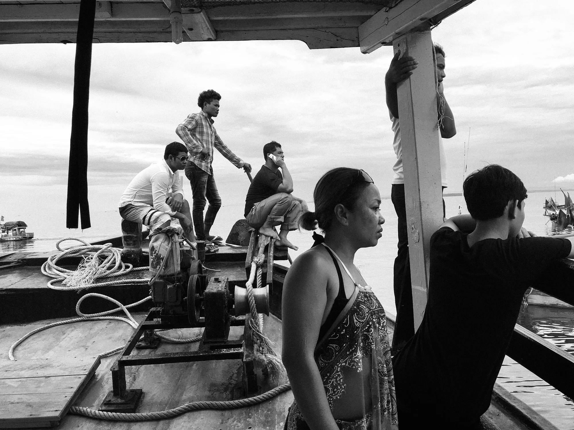 Tourist and crewmen watch fishermen scramble as the captain talks on the phone. I don't know who he was talking to. 