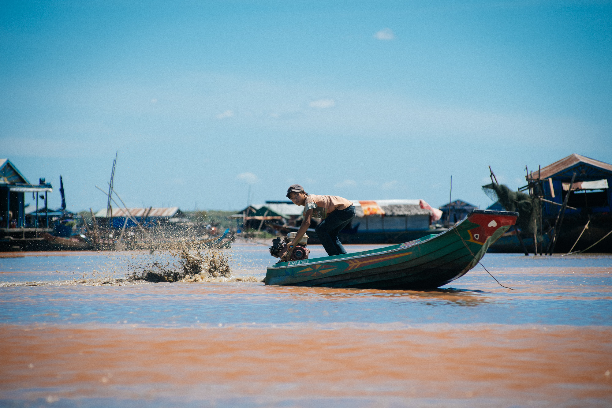 Man takes motorcycle batteries to recharge at the floating mechanic. All boats run with a motor from a motorcycle. 