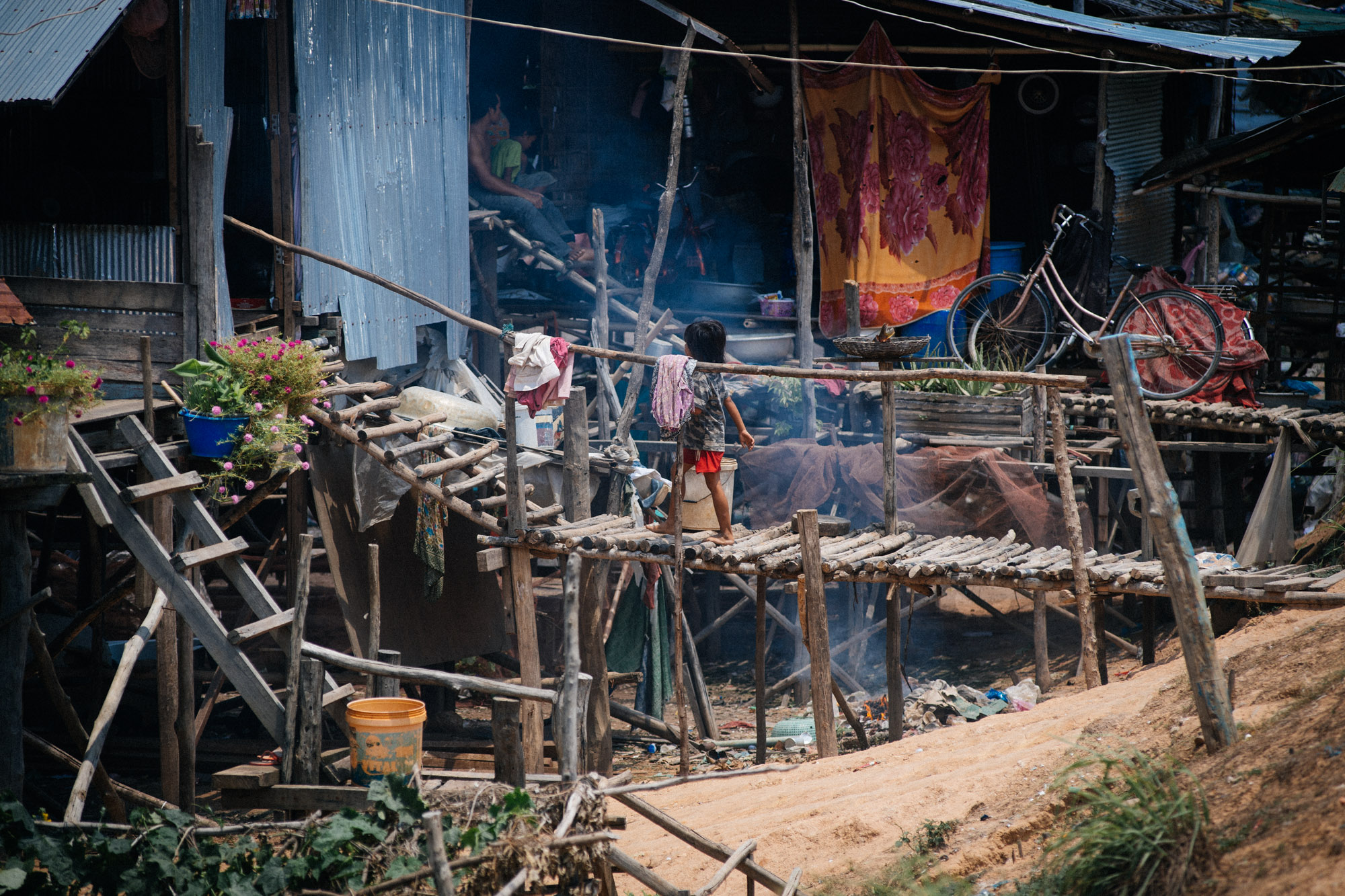 Villages like these are a common site in the countryside of Cambodia. Made with wood and construction leftovers, dozens of people live with no doors and little privacy.
