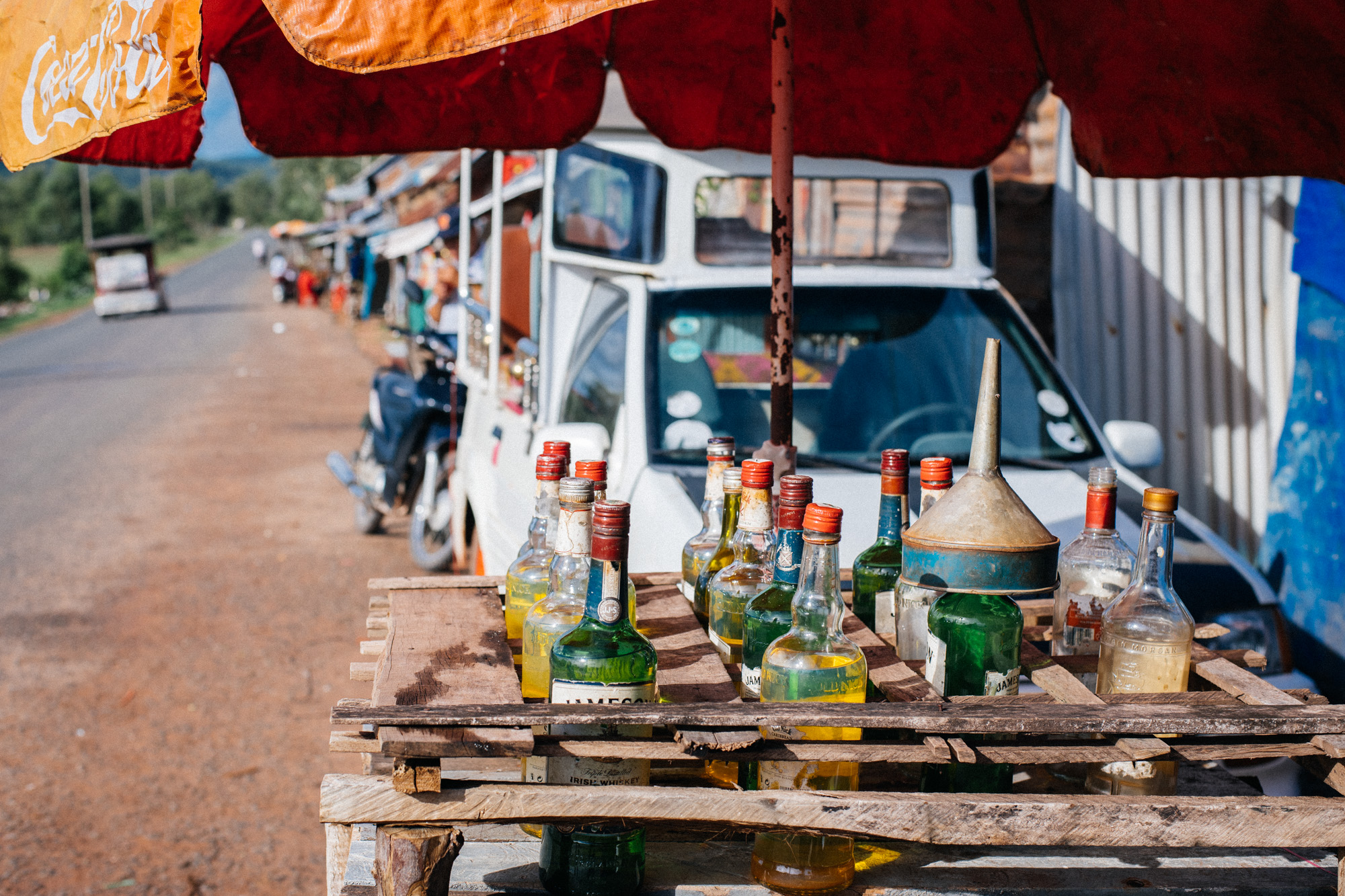 On the same little strip, a little bit down the road, gasoline is sold in whiskey bottles.