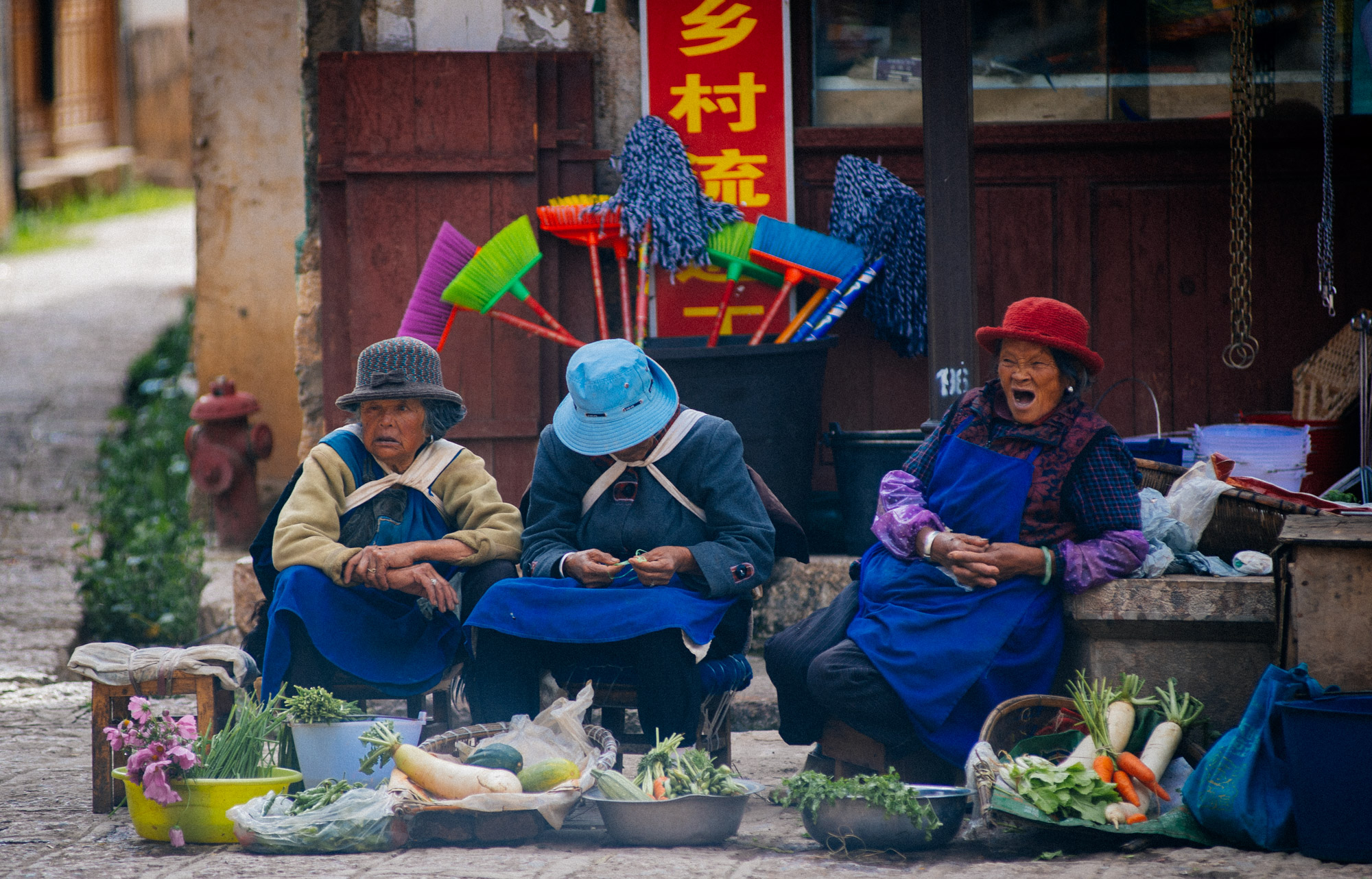  Naxi women sell produce in the village main square. 