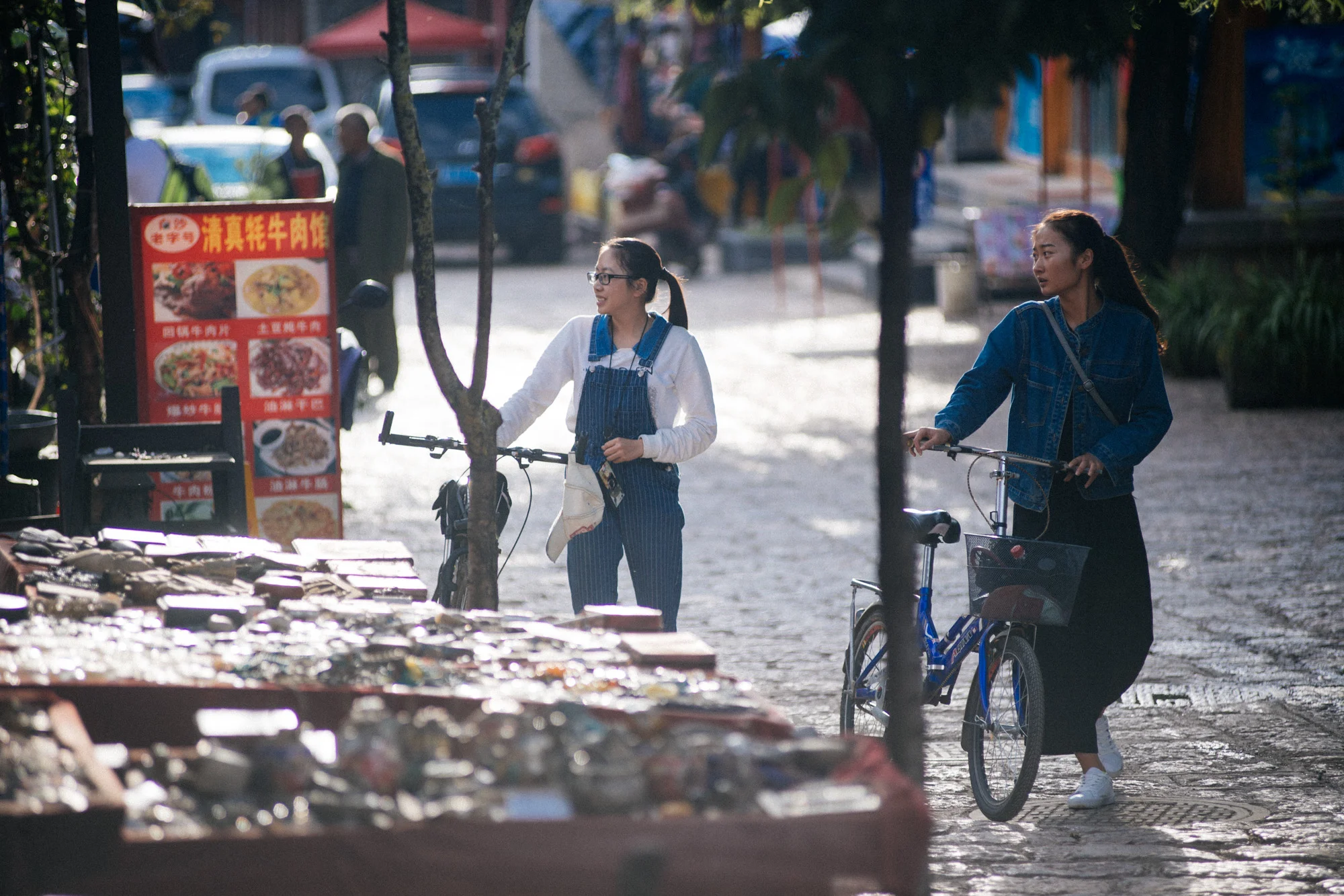 Two Chinese tourists browse souvenir and antique shops in the evening.