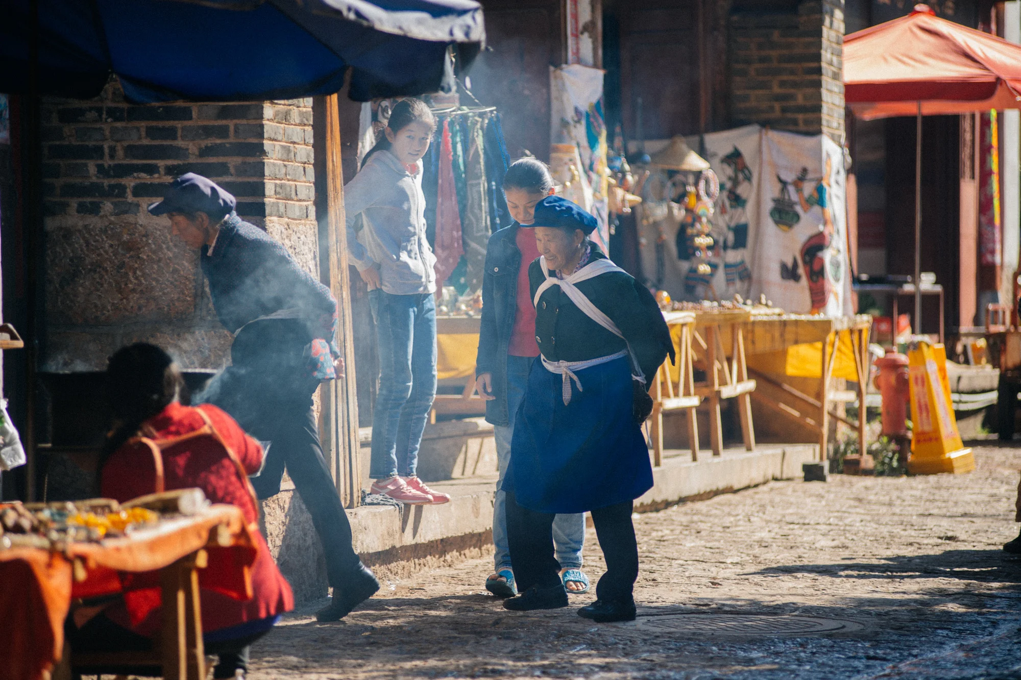 Group of Naxi women enter a restaurant in the evening.