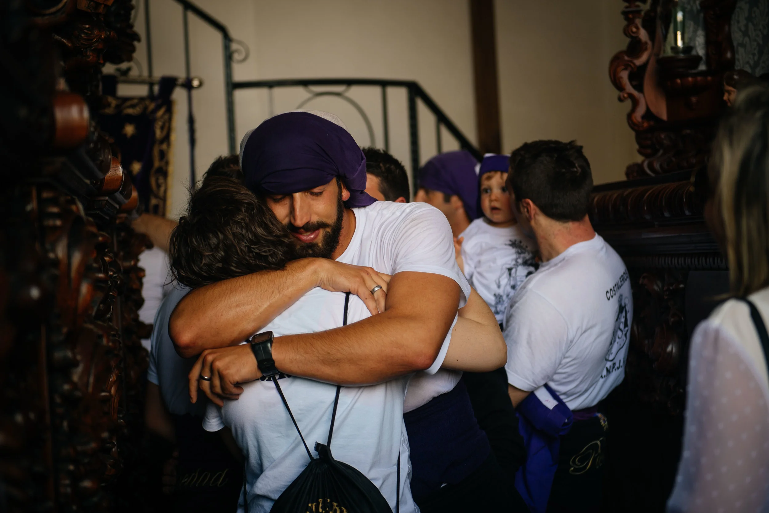 Antonio Caparrós hugs a relative with tears in his eyes as he walks out from under the statue he was carrying. Caparrós every year takes part in the procession in memory of his late uncle that did it before him.