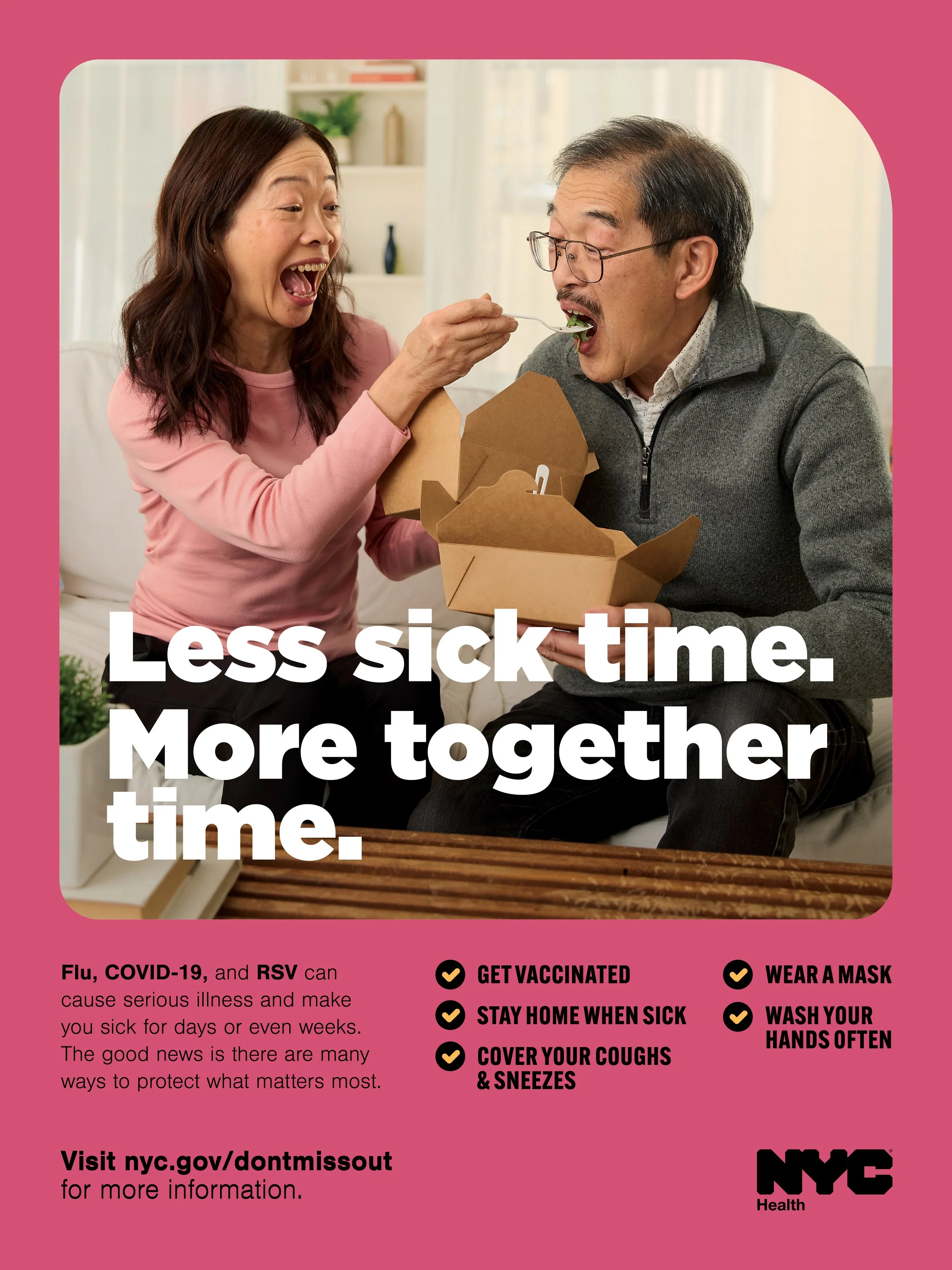 A woman feeds an older man with a takeout container and a fork, both smiling. They are inside a bright room with shelves and plants in the background. The image promotes reducing sick time by getting vaccinated, staying home when sick, covering cough