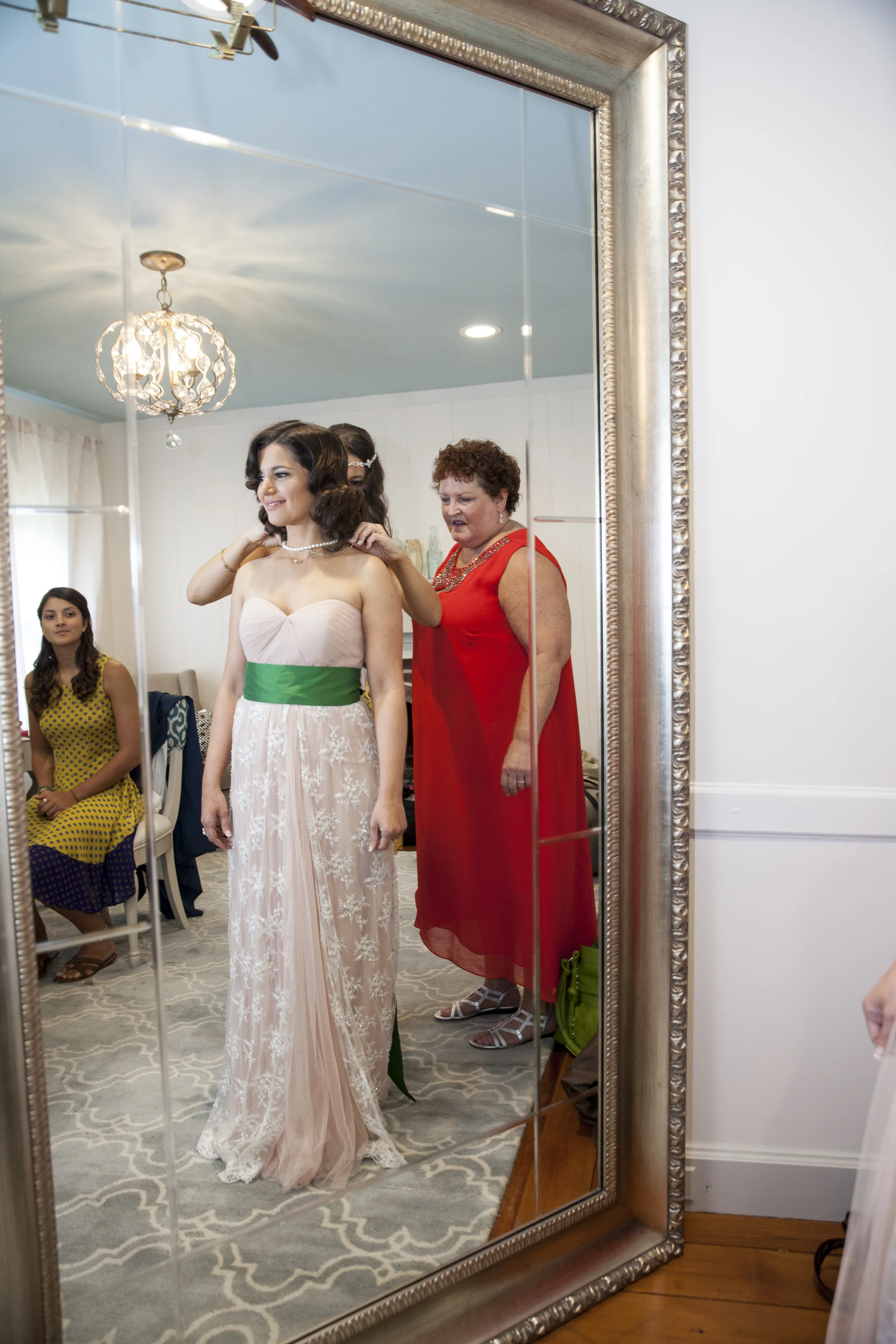 Wedding attendants help the bride prep for the ceremony