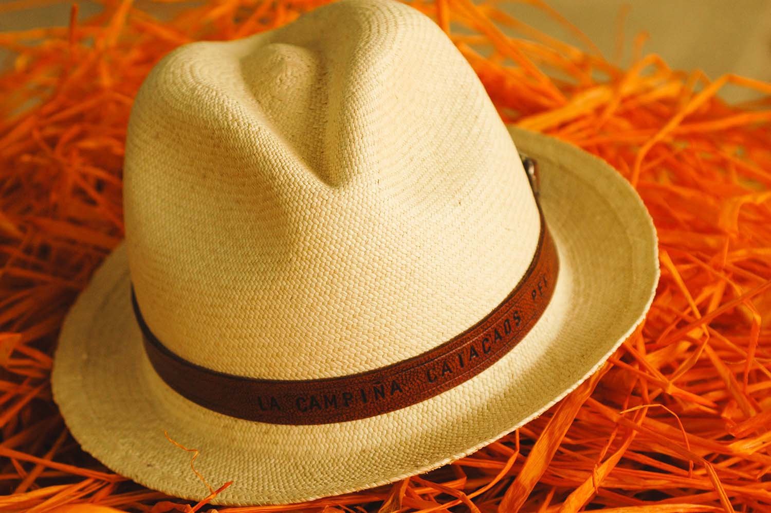 Natural straw hat sitting on a pile of orange straw