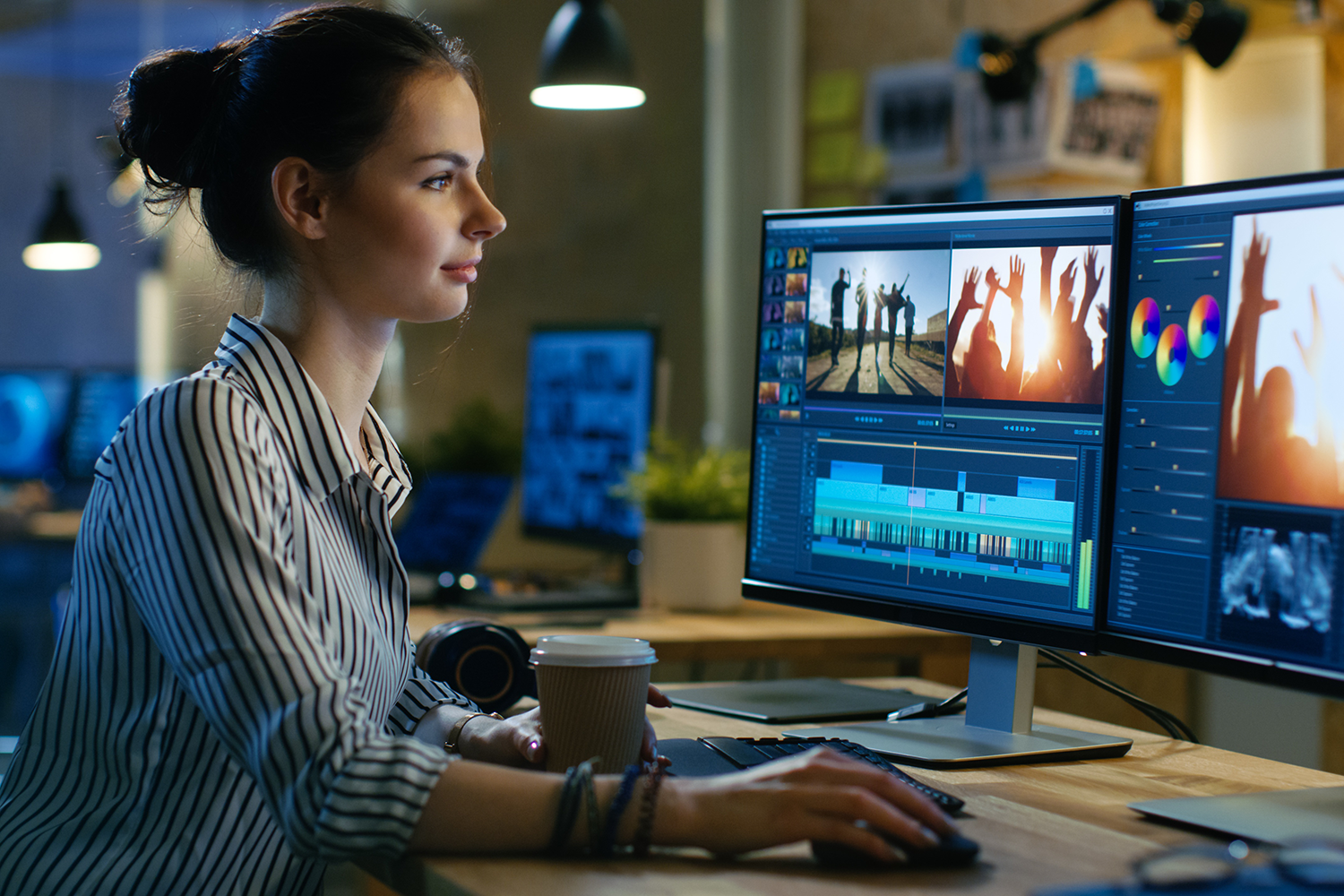Video editor sitting at their desk in front of two computer screens