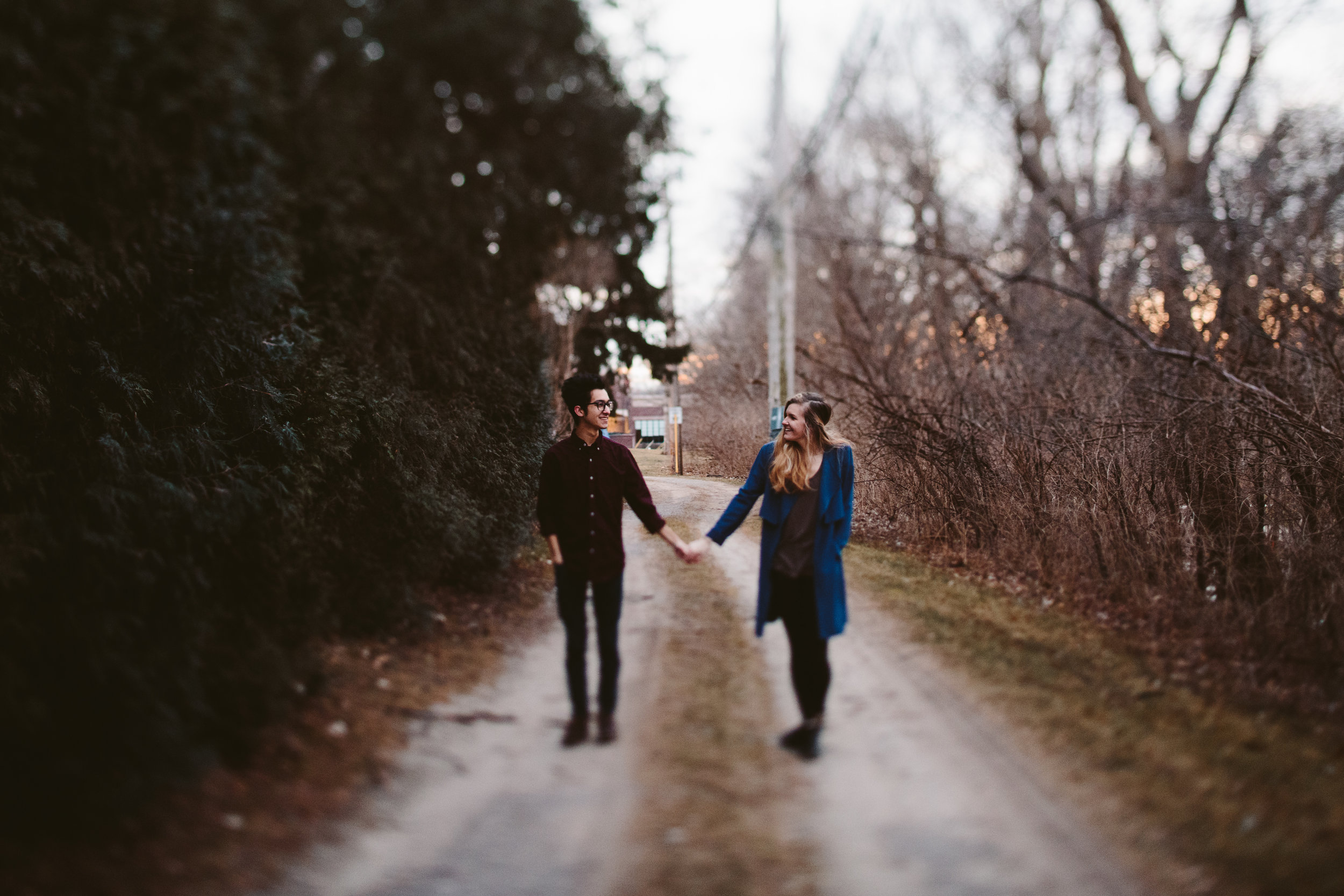  couple holding hands during northern michigan forest engagement 