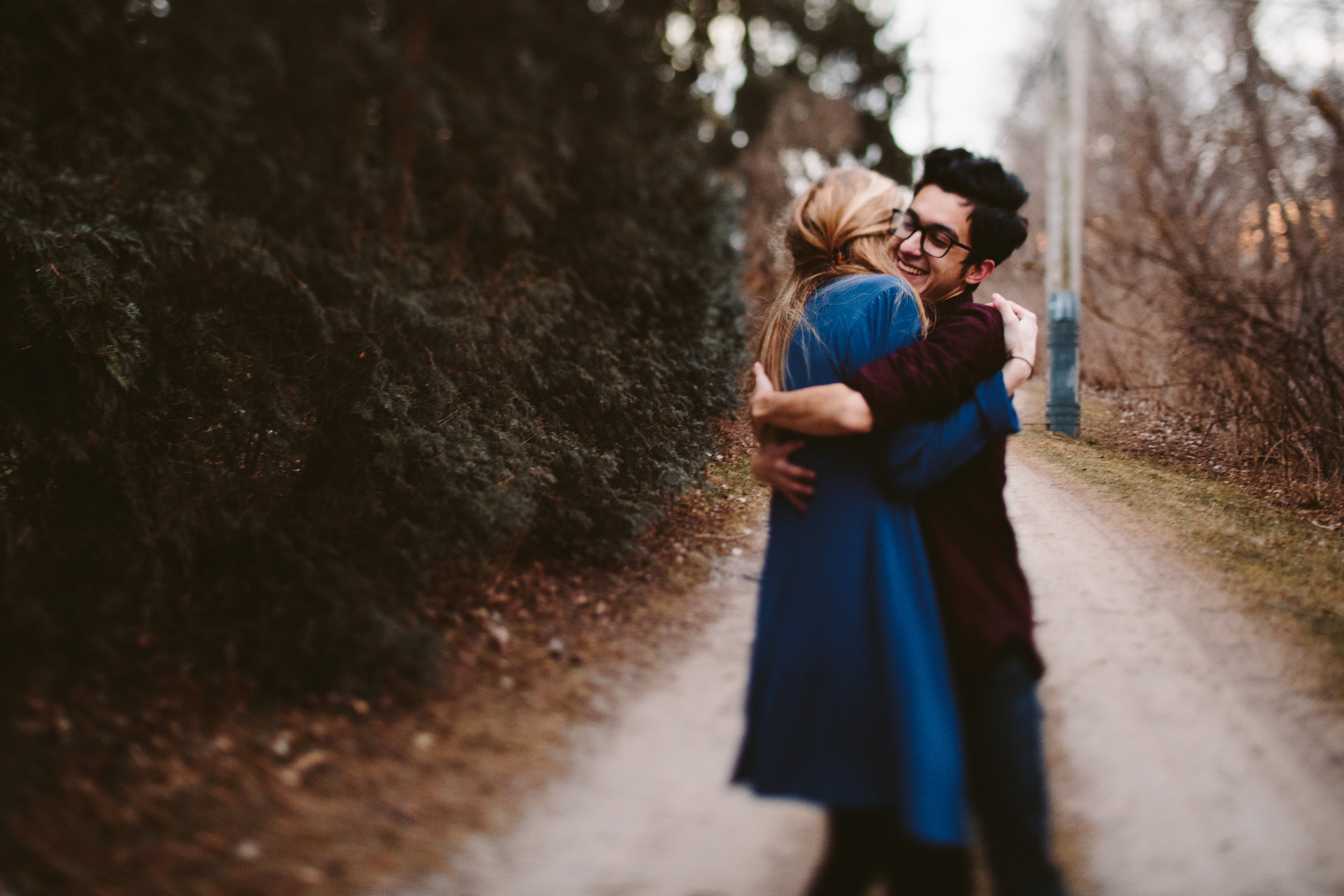  couple embracing during traverse city forest engagement 