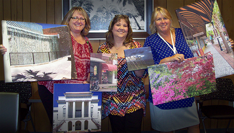 Ginger Ash, Job Preparedness Instructor; Michelle Stockman, Vocational ACE; and Carolee Dunn, Center Manager, with some of their photography which is now on display throughout the Walterboro VR Office.