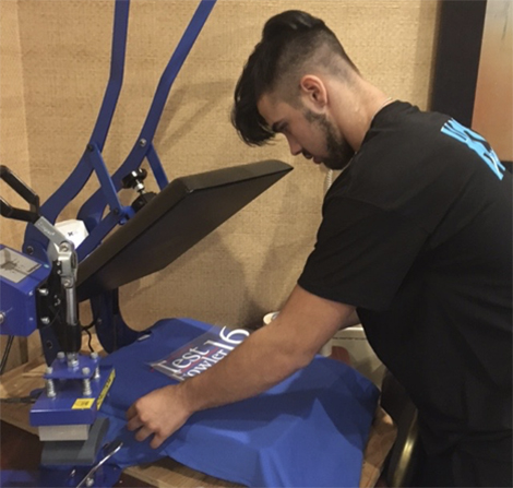 Tyler Spainhour, a junior from North Myrtle Beach High School, operates a heat press machine. Tyler has also learned to operate a Cricut machine.