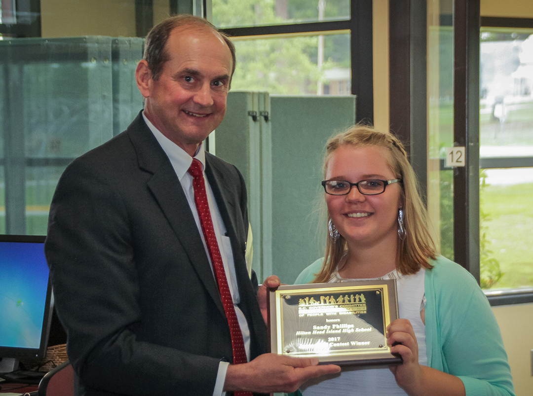 Sandy Phillips of Hilton Head Island High School is recognized as winner of the Governor’s Committee on Employment of People with Disabilities Journalism Contest by Mark Wade, Governor’s Committee liaison for the SC Vocational Rehabilitation Department.