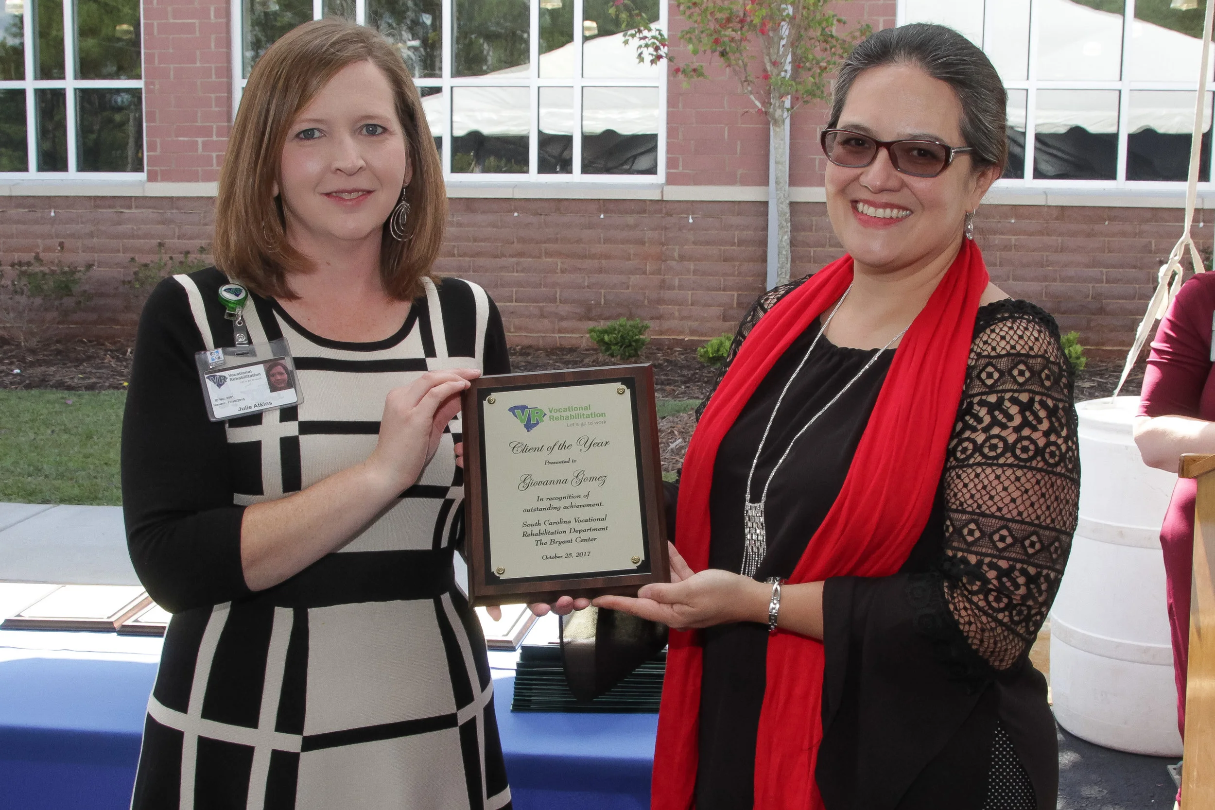 Former VR client Giovanna Gomez (right) receives the Lyman Office Client of the Year award from Julie Atkins, Area Client Services Manager.