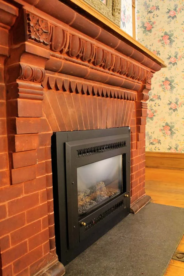 Gas Fireplace of Conservatory- Room 1 featuring antique brick with egg and Dart pattern.