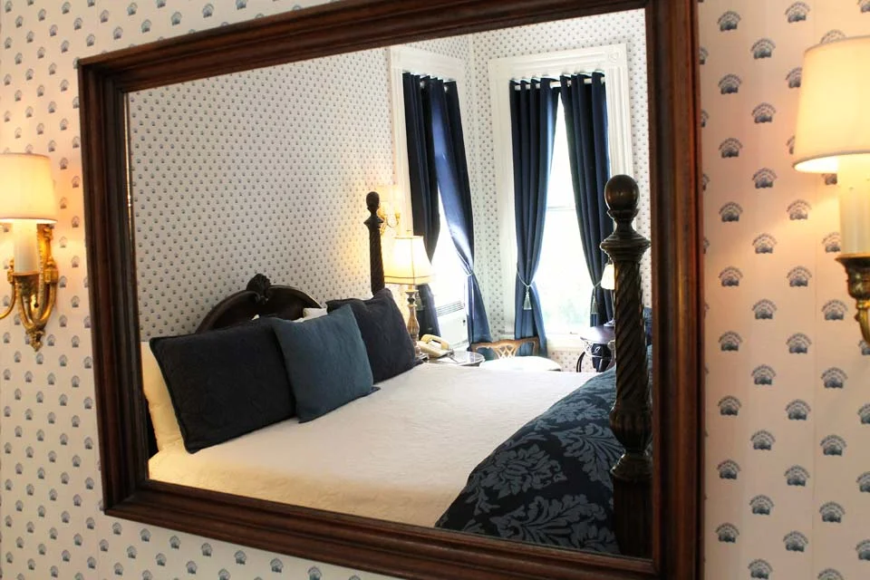 Large mirror over fireplace reflects light around the Nantucket room at WSInn.