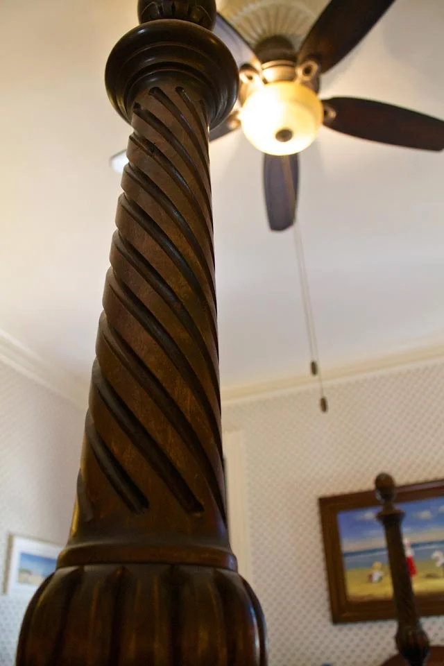 Close-up of carved wooden post of king, four-post bed in Burlington, VT B&B.