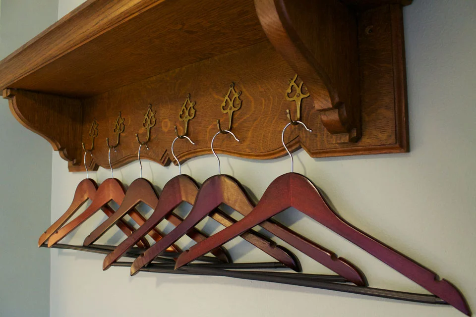 oak wall shelf with plenty of hangers for your traveling cloths in Room 15.