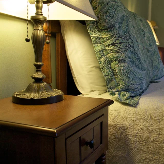 Wooden bedside table provides a perfect place for a good book next to Lindsey’s Loft double bed with wooden headboard.