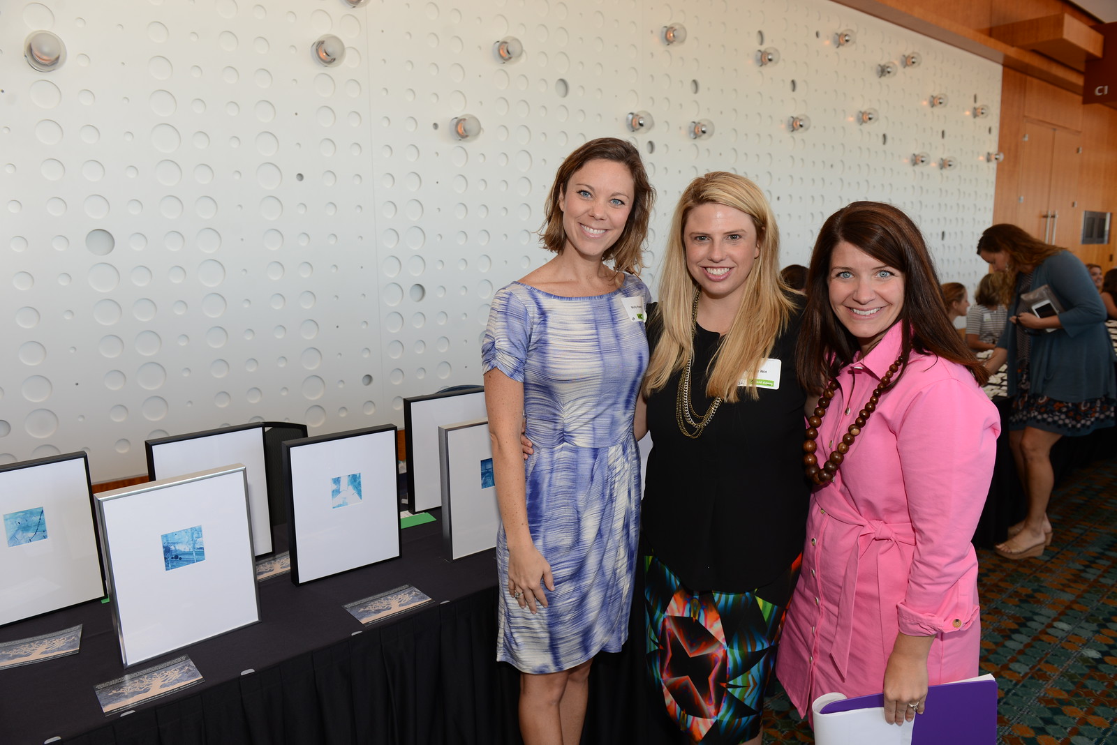 Local artist Molly Howell with board members Whitney Akin and Callen Martin. The framed artwork on the table is from a tree collage painting made by ESTN survivors.