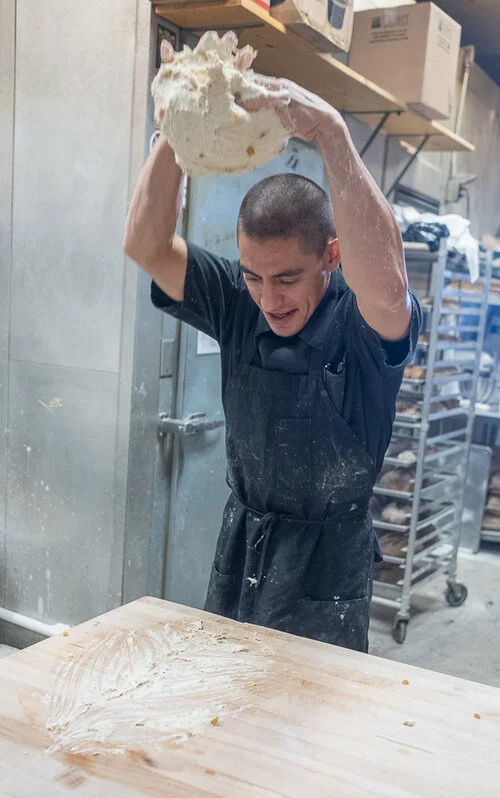 After the 3-day fermentation, our dough starts wet, requiring Gabriel to slam it repeatedly on the table.