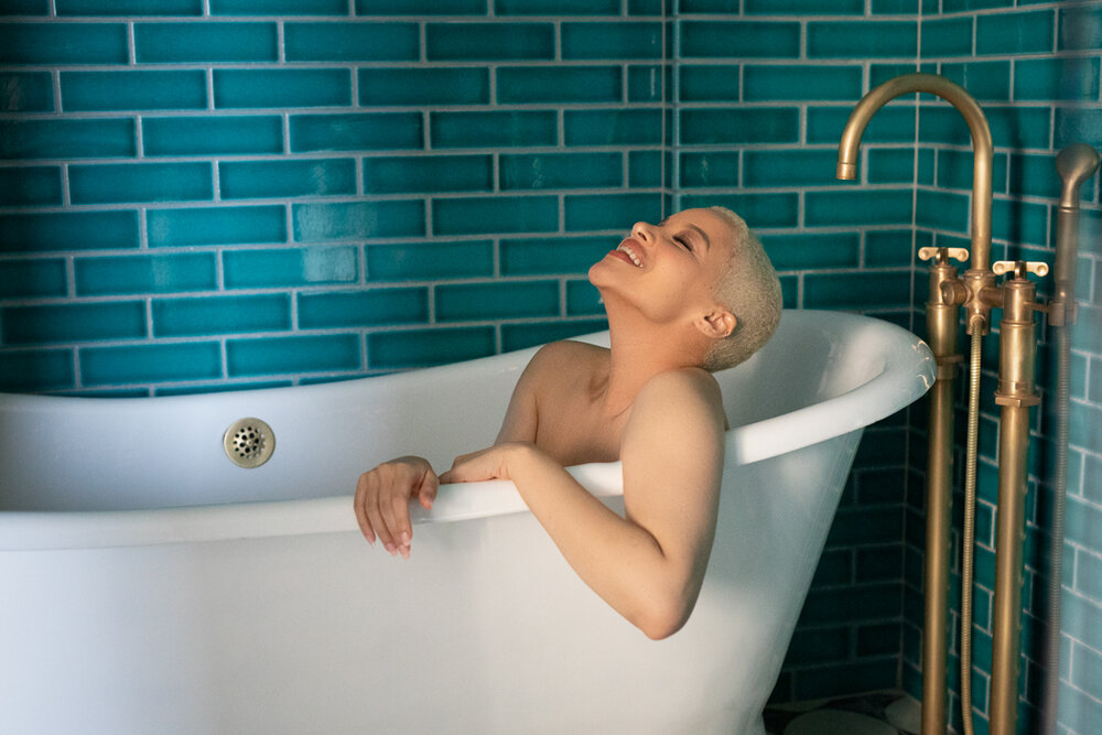 woman smiling in bathtub - seeing your true self on valentine's day