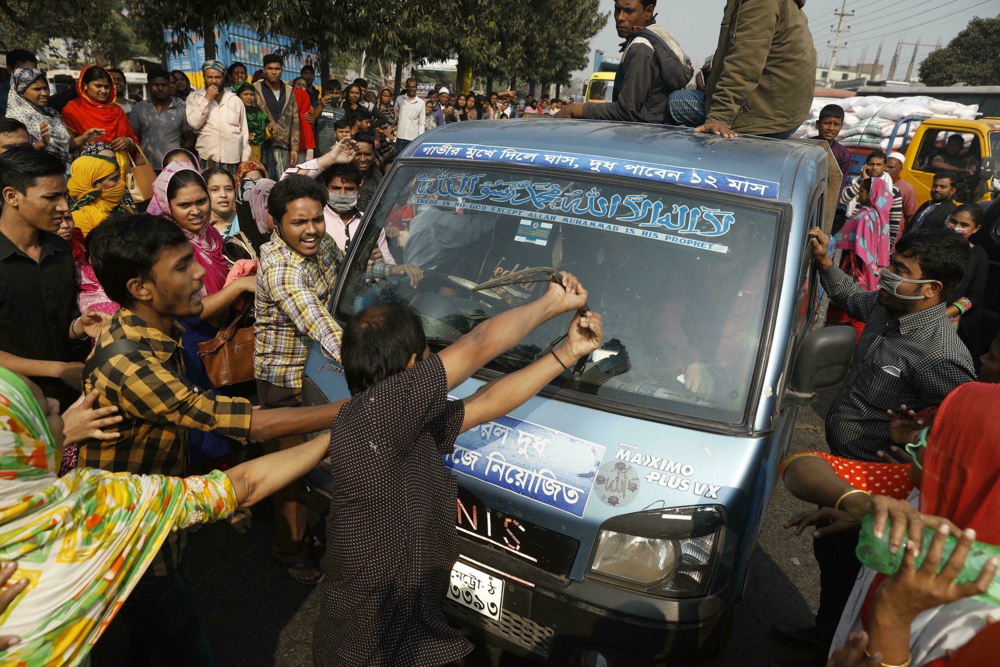 In this Wednesday, Jan. 9, 2019 file photo, Bangladeshi garment workers vandalize a vehicle during a protest in Savar, on the outskirts of Dhaka, Bangladesh. Kalpona Akter of the Bangladesh Center for Worker Solidarity said Thursday, Jan. 31, that more than 5,000 garment workers demanding wage hikes have been laid off while hundreds of them are facing police charges in the world’s second-largest garment export industry. She said the firings came after thousands of workers took to the streets earlier this month in and around Dhaka, the nation’s capital. (AP Photo)