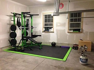 Simple-and-clean-heated-garage-gym-with-green-weight-bench-set-wall-balls-and-yoga-mats.jpg
