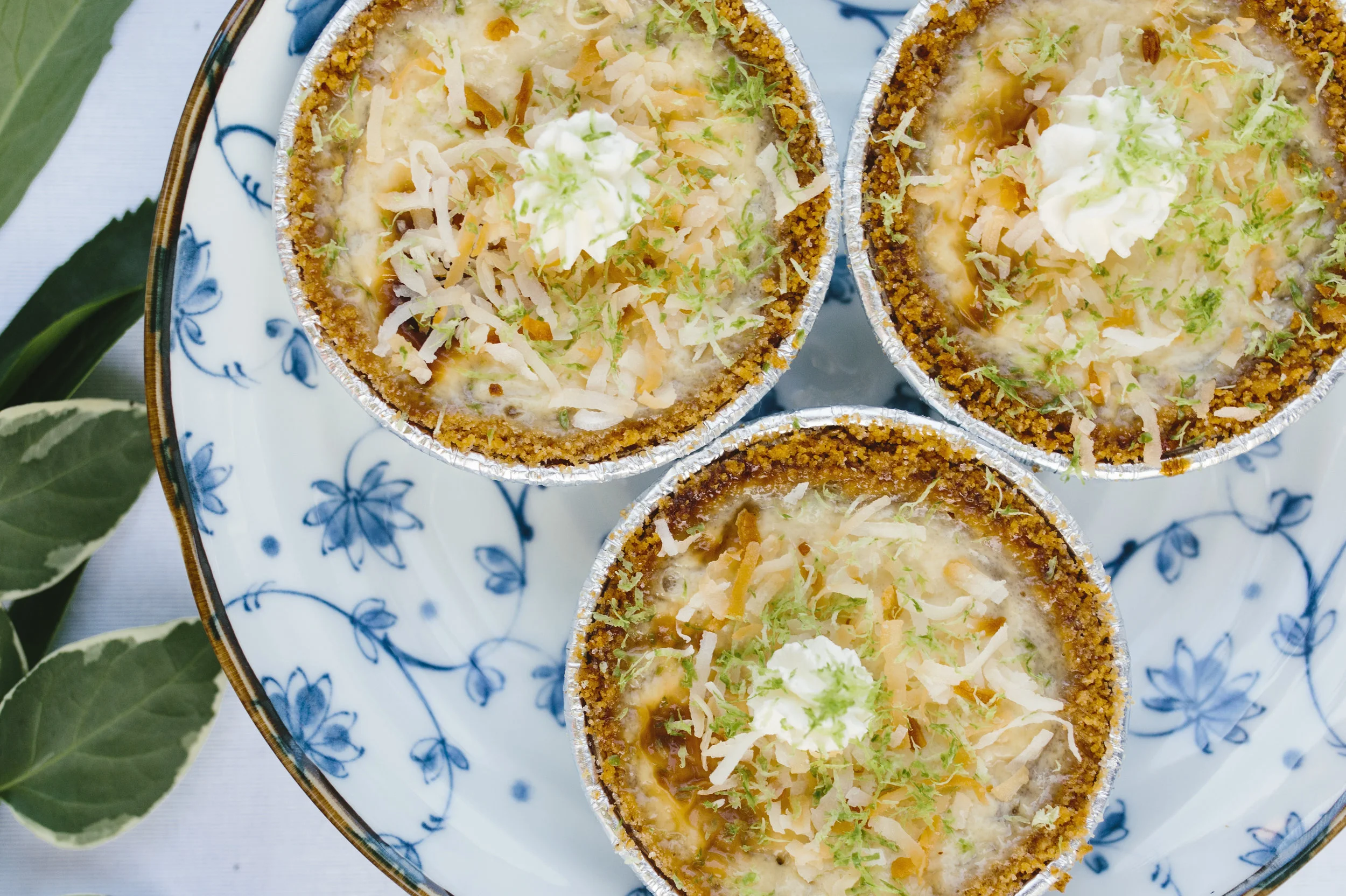 The Coconut Key Lime pies topped with handmade whipped cream, lime zest, and some toasted coconut shreds.