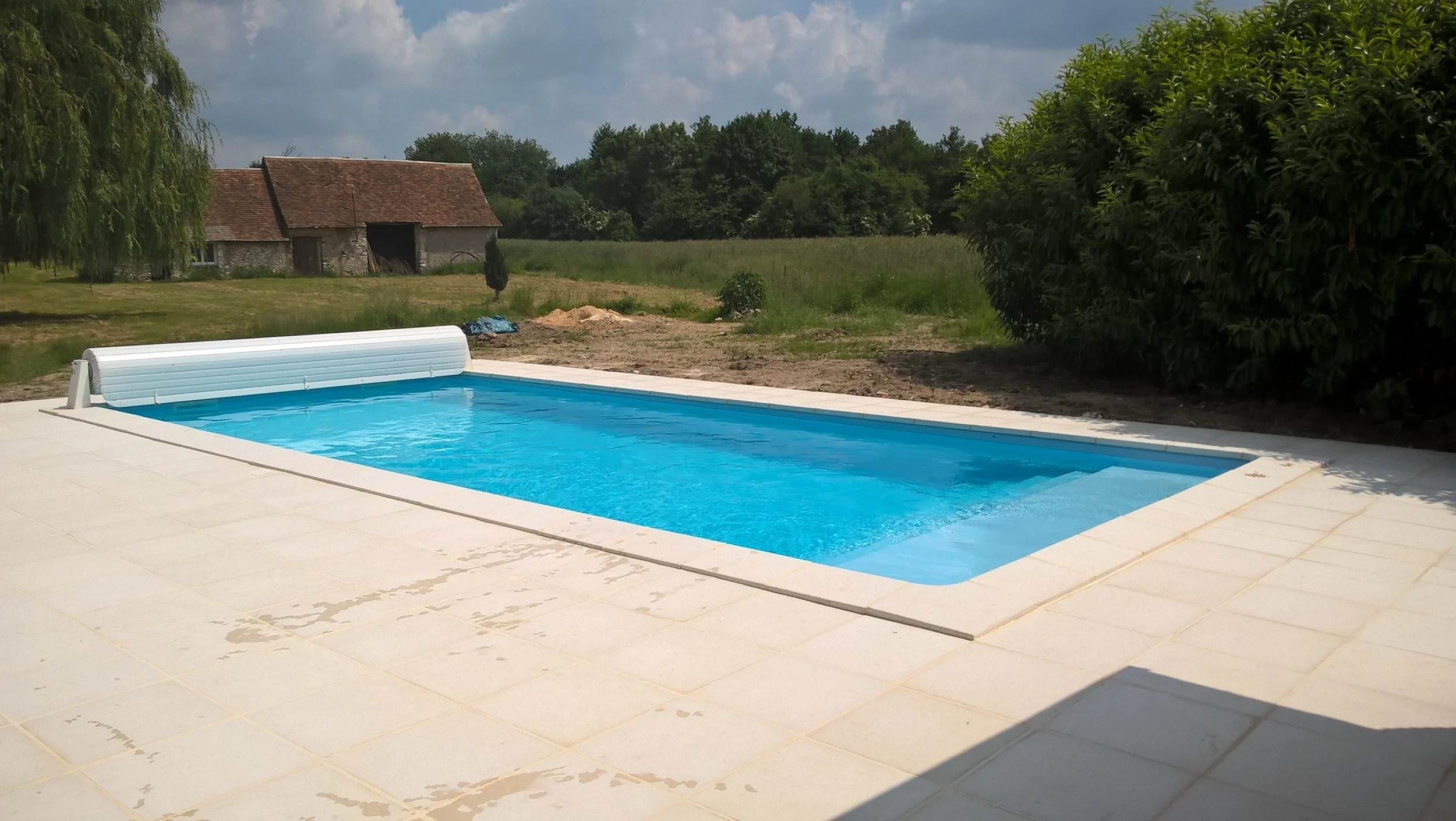 9 m by 4 m in-ground pool with full width steps, clear blue liner and stone terrace.