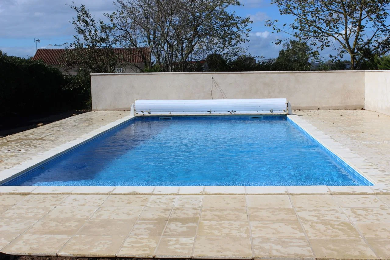 11 m by 5 m in-ground pool with mozaic blue liner and stone terrace.