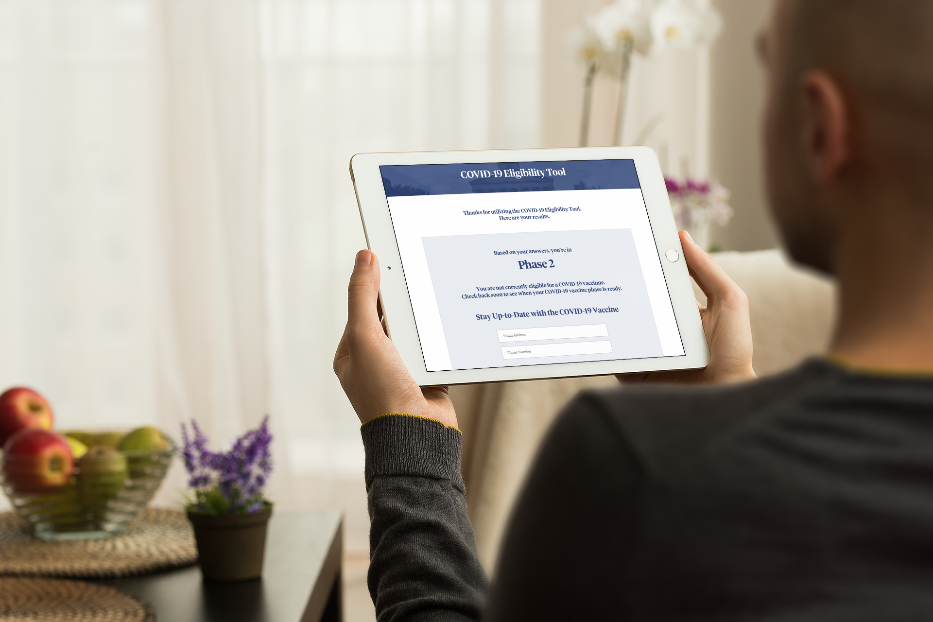  Man in a long sleeve shirt using the COVID-19 Information Hub on his tablet.  