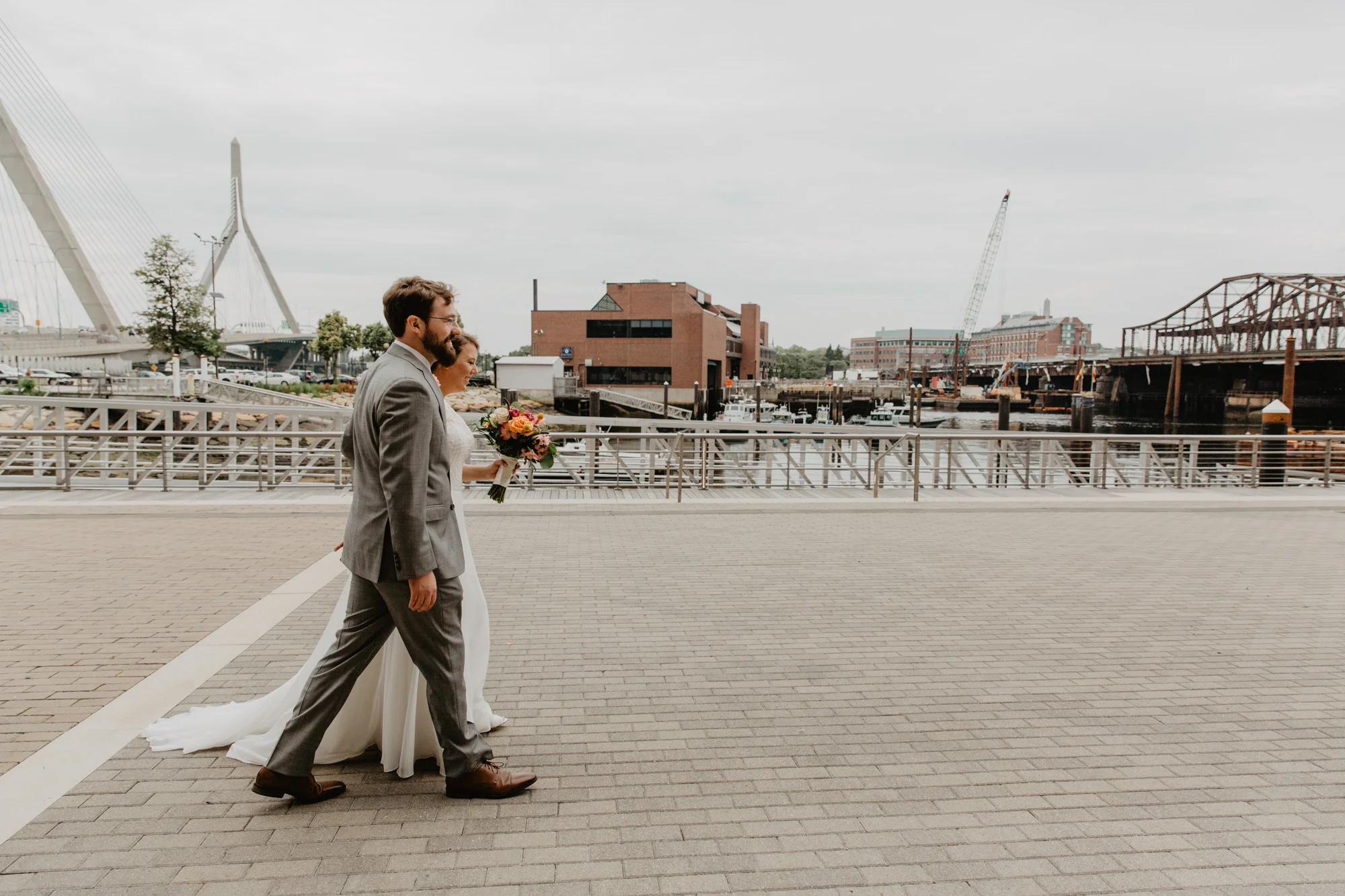 Bride and groom walk along Lovejoy Wharf in Boston