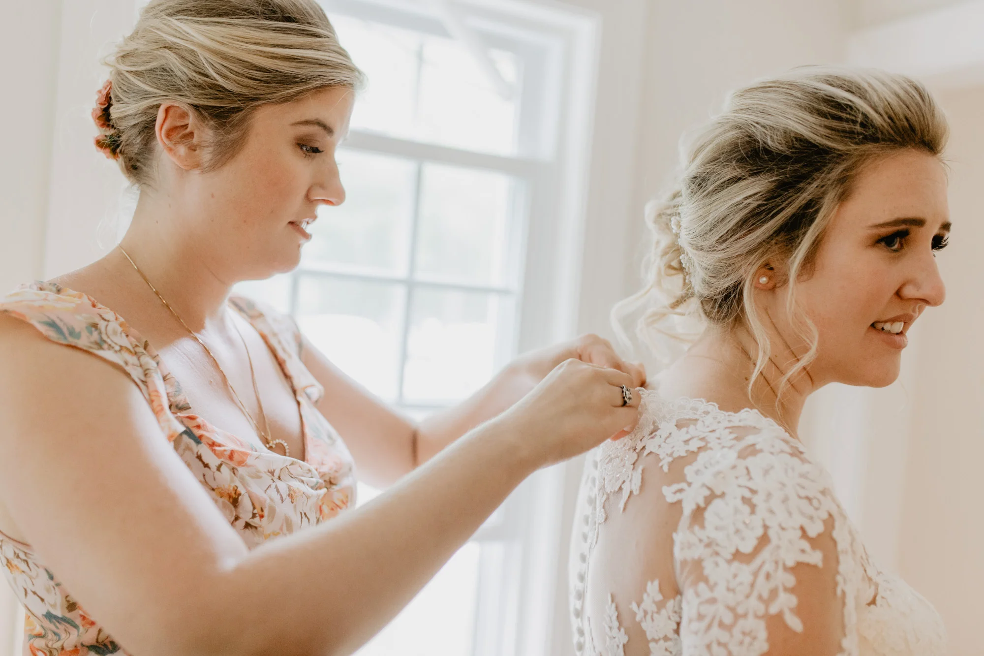 The bride buttons up her wedding dress