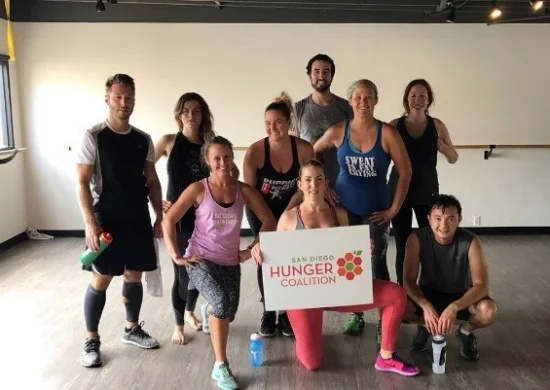 Participants in the San Diego Hunger Coalition’s Work out to Fight Hunger at Ashley Lane Fitness pose to show their support after their workout.