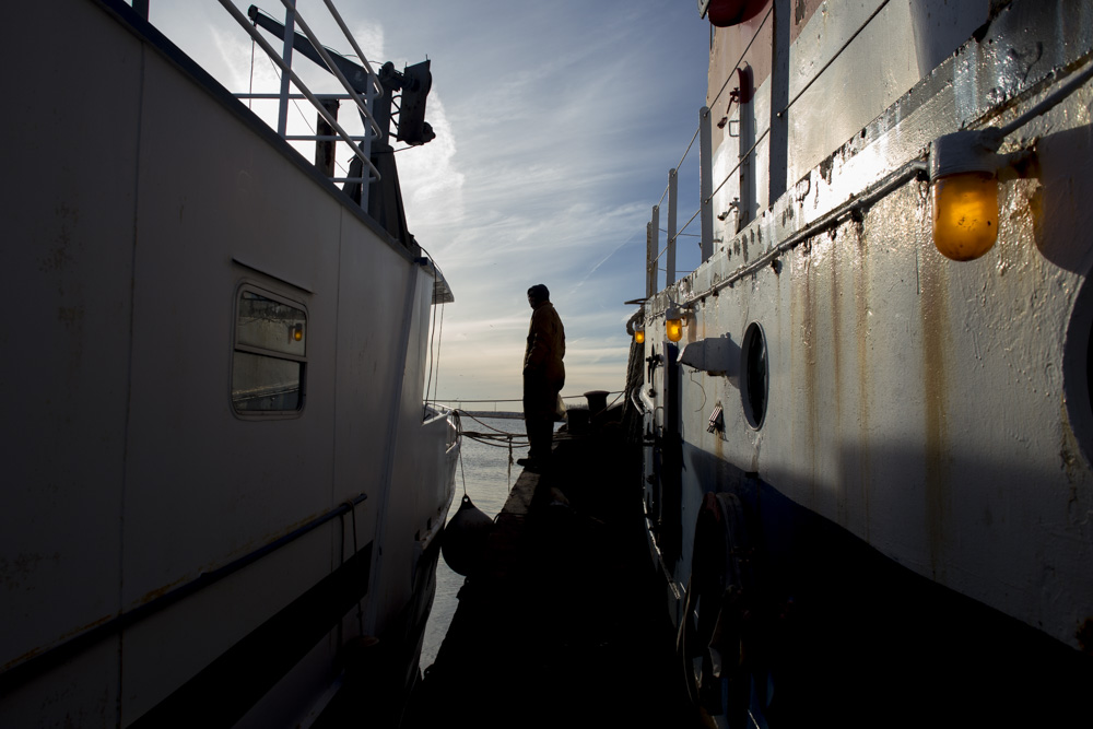  Mike Vinik stands on the edge of his tug,&nbsp; Charles Oxman , preparing to cross to the houseboat he lives on outside of Perth Amboy, New Jersey.&nbsp; 