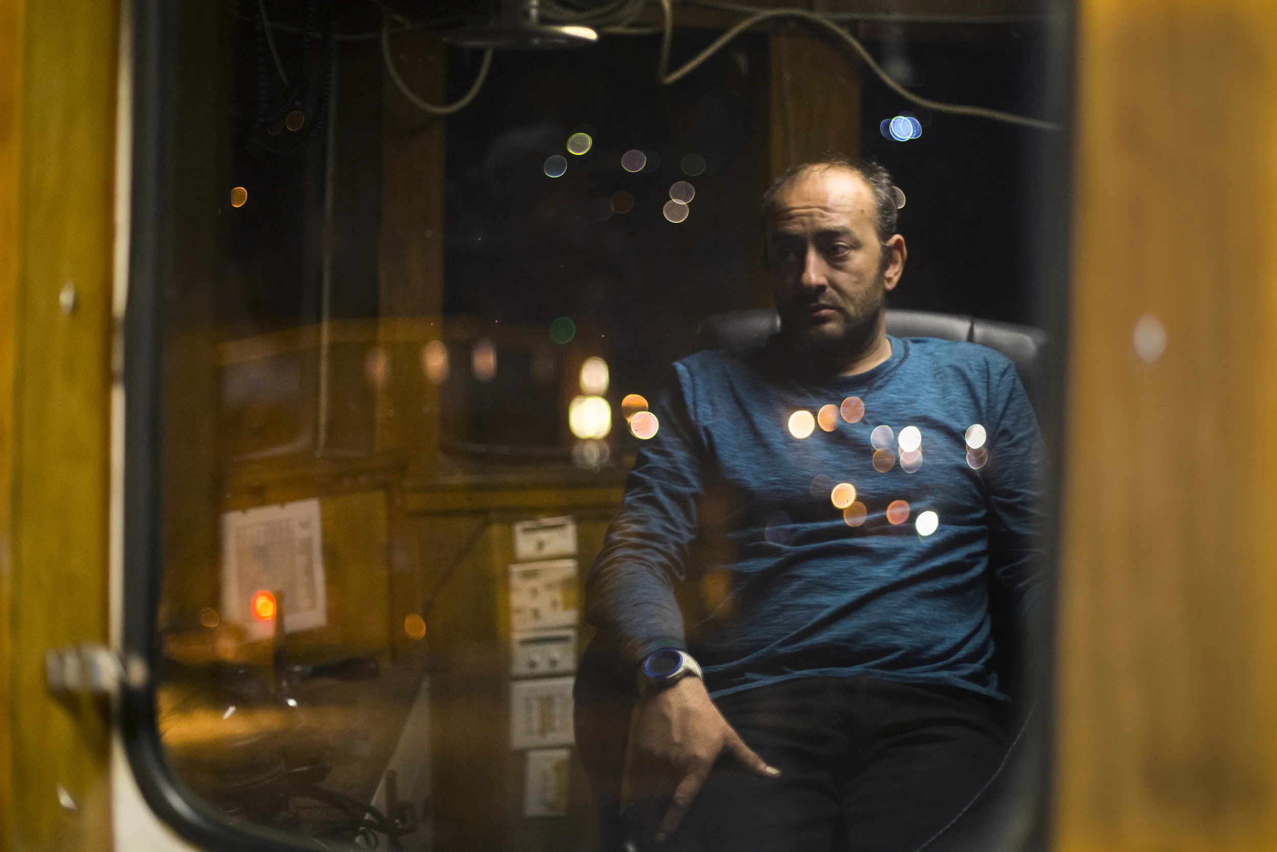 Mike Vinik, the owner operator of Vinik Marine, a tugboat business in the Tri-state area, looks out over the East River while on a night run delivering an oil barge to the Bronx to heat homes. 