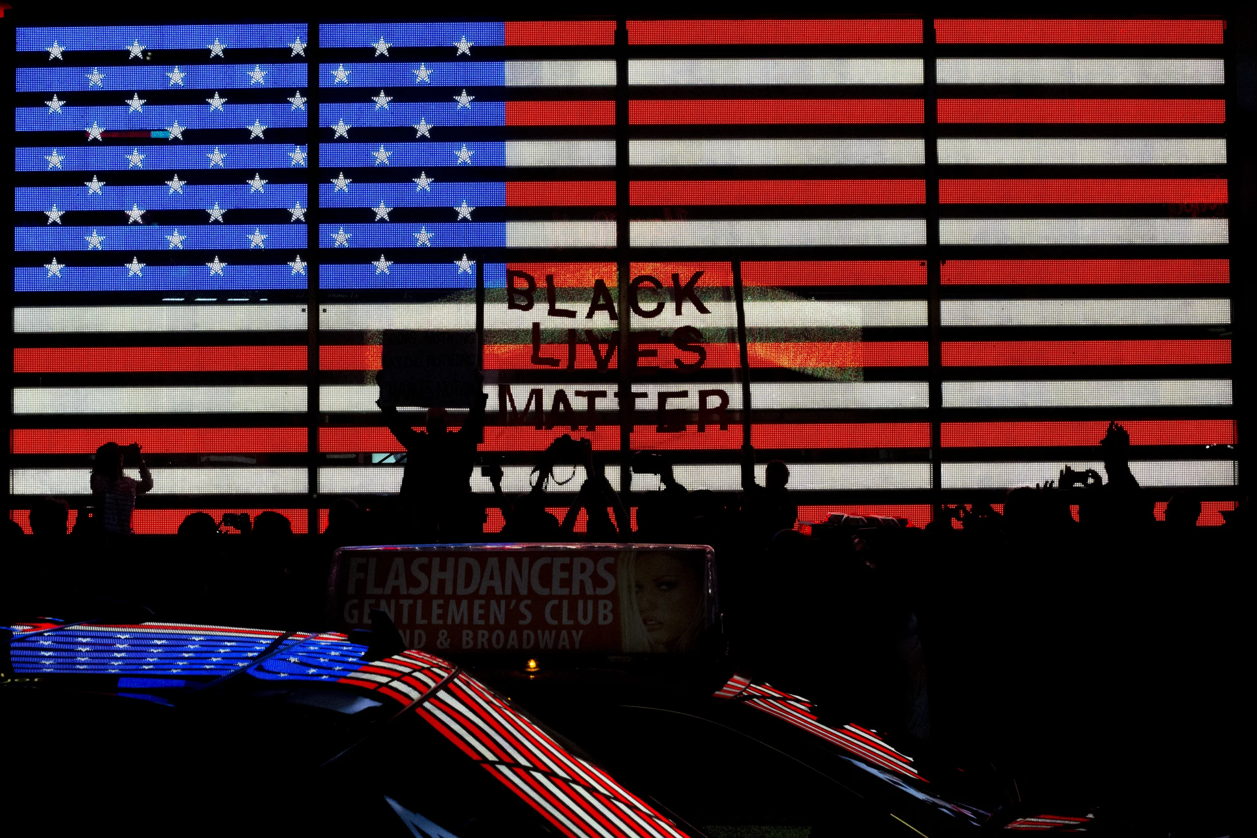 Protestors carrying a large "Black Lives Matter" sign cross in front of the LED American Flag in Times Square during the first night of protests against the decision not to indict Darren Wilson, the Ferguson police officer who shot Michael Brown, an unarmed 18-year-old. 