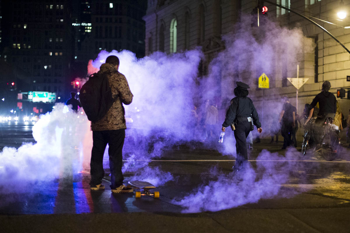  A protestor checks his phone next to steaming manhole covers in lower Manhattan on the first night of protests against a Missouri grand jury's decision not to indict the police officer who shot Mike Brown, an unarmed 18-year-old in Ferguson, Missour