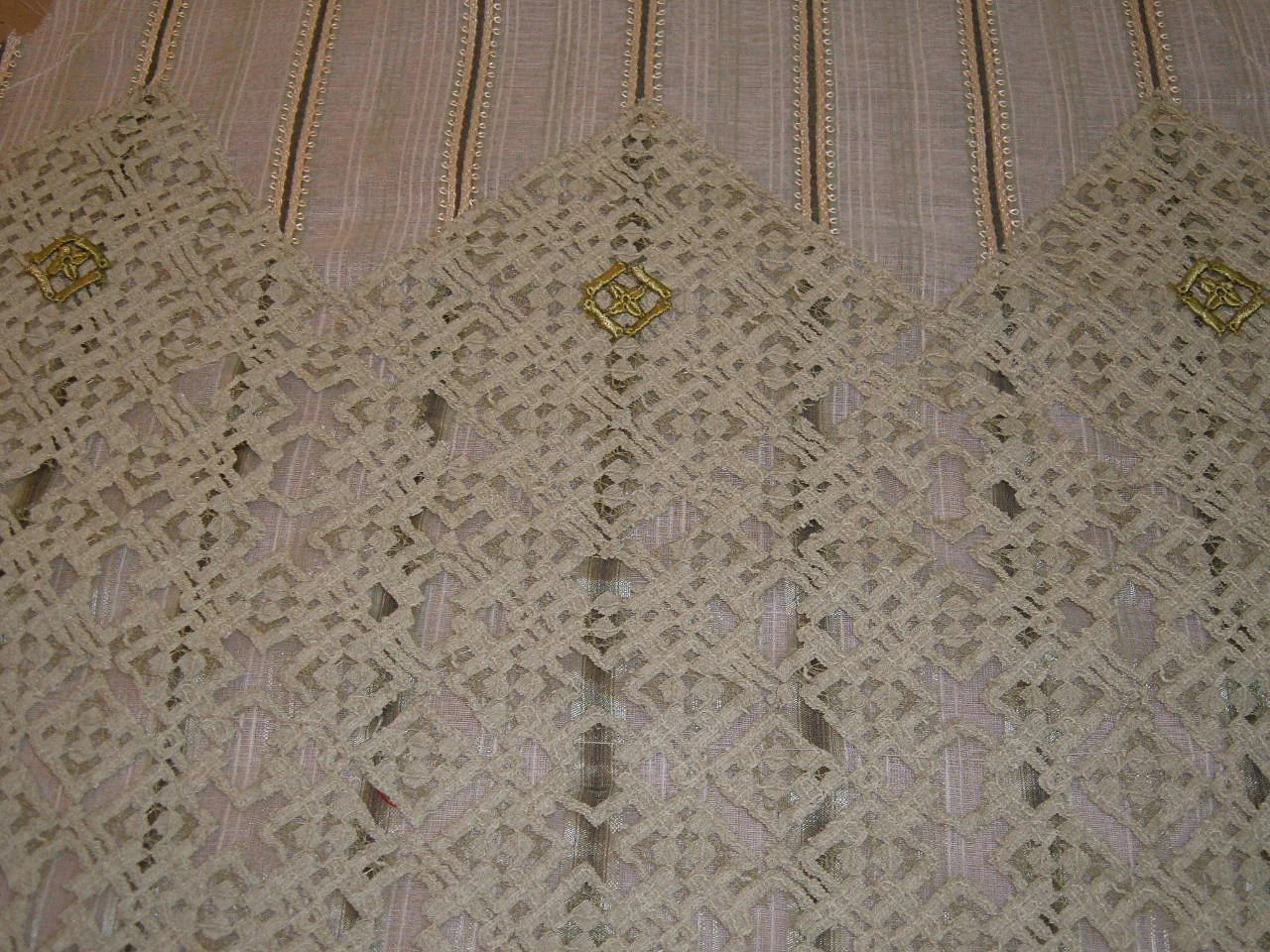   fabric making- this is a white base fabric, with vertical ribbon trim stitched at the top and a lace applied to the lower section. The lace was cutout in a repeated pattern create a diamond border with a more open,airy pattern below that, and then 