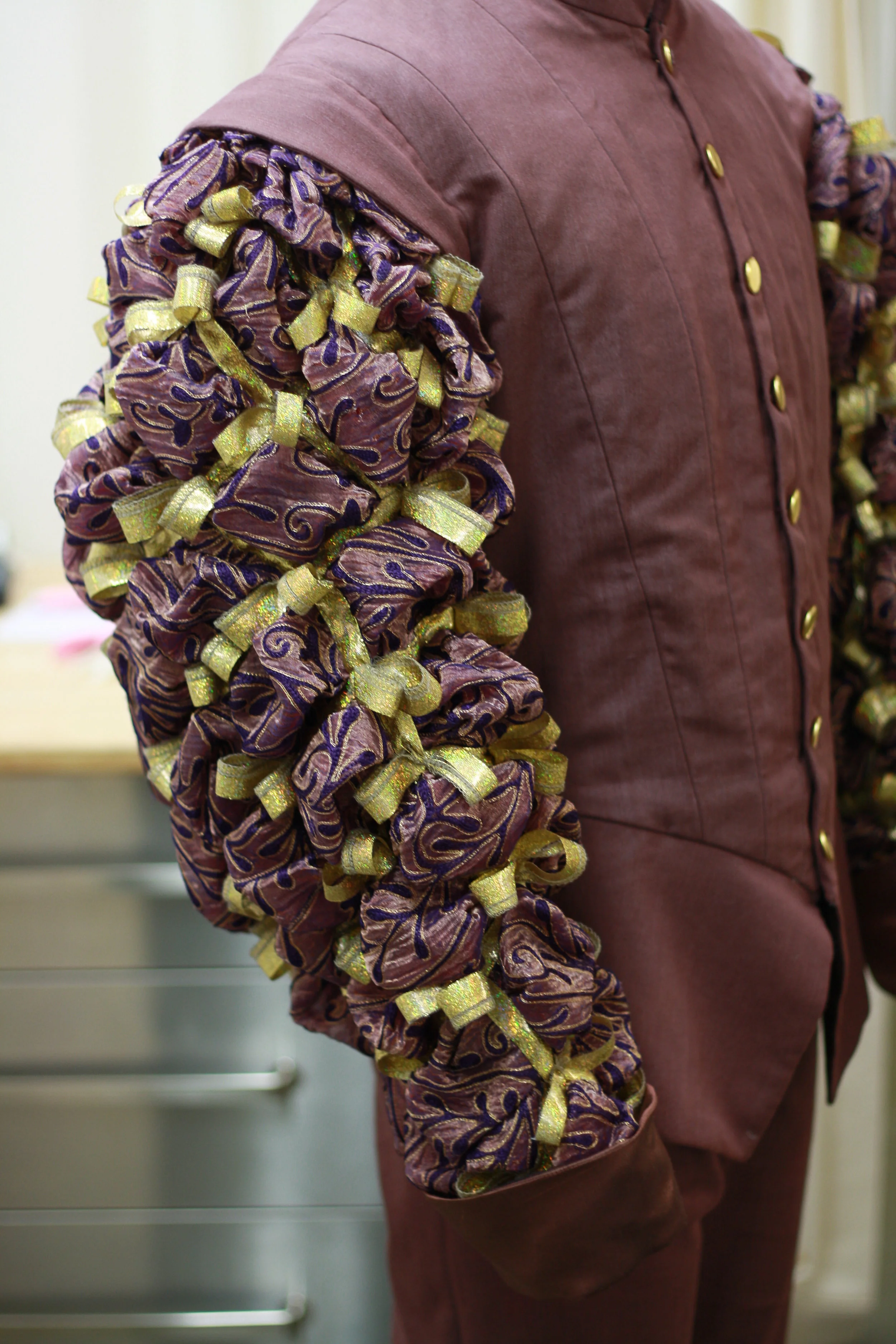   fabric manipulation- fabric tucked to create a textured diamond pattern, highlighted with gold ribbon and bows The Taming of the Shrew /The Old Globe/2010 design by Deirdre Clancy/draping by Randal Sumabat 