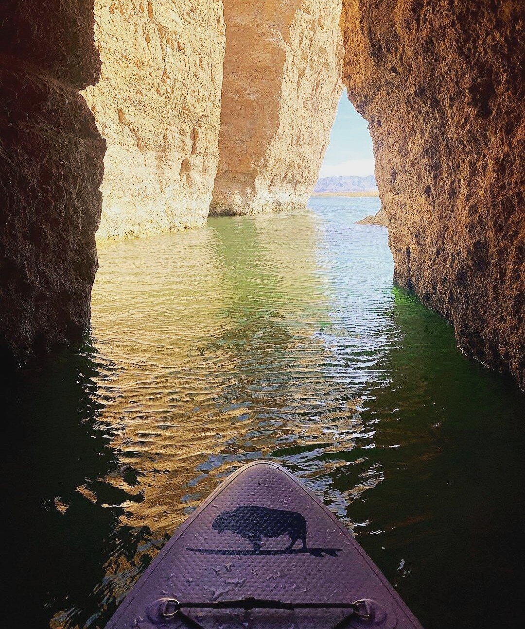 Inflatable paddle board crossing Lake Havasu with large rock formations
