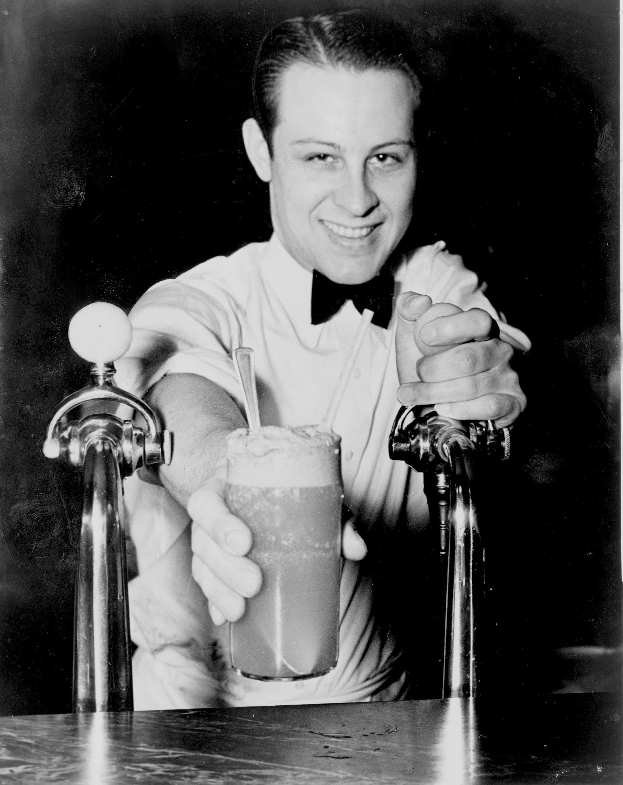 A Boston Cooler or Vernor's Float, being served with a smile by Eddie Skinks of Detroit's little known corrupt soda fountain gang. Not tipping Eddie proved to be a mistake.