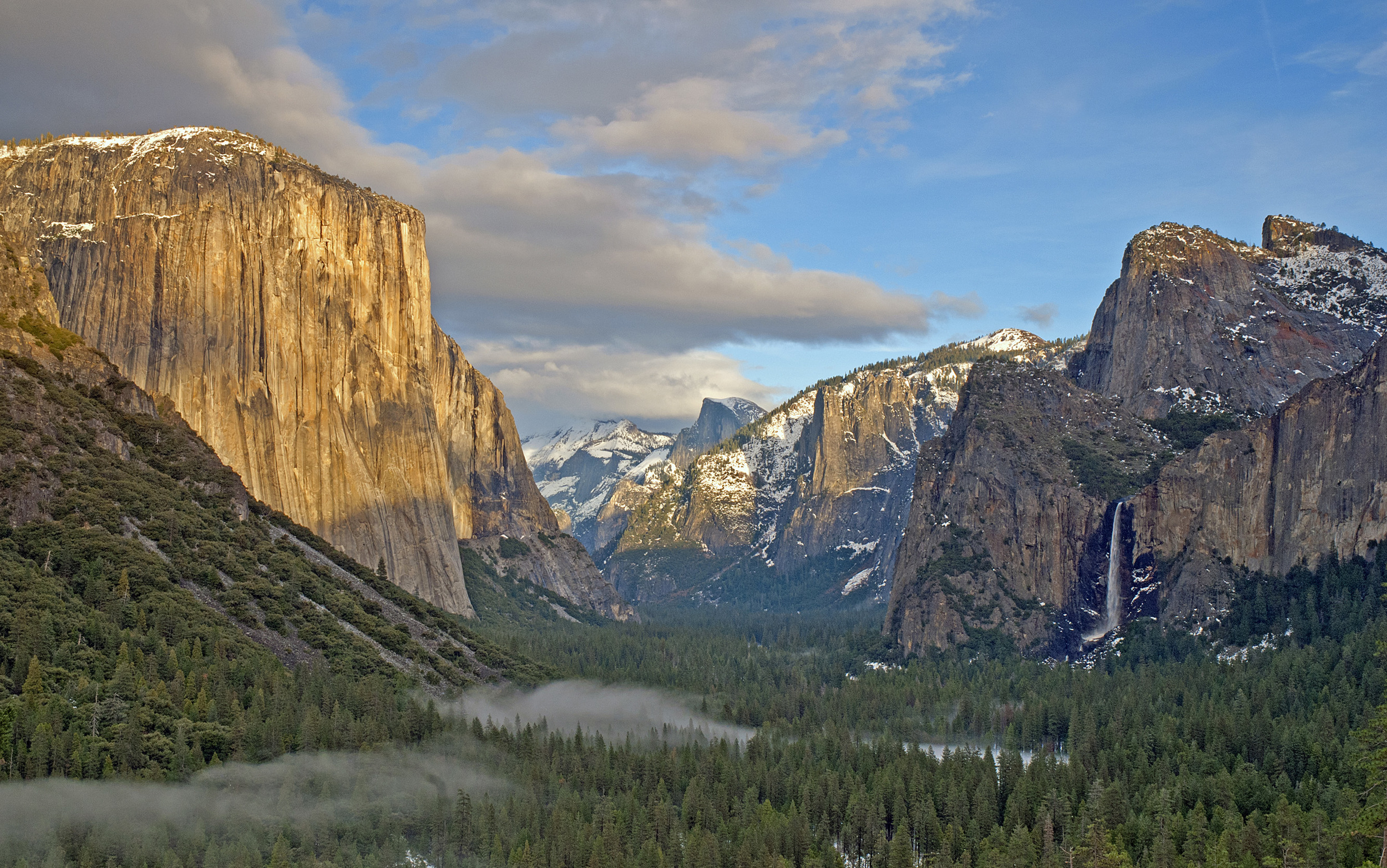 A tunnel view of Yosemite Valley, with Half Dome in the distance. The waterfall on the right is over 2,500 feet tall. The fog along the bottom of the valley was created by the National Park Service for ambiance. 