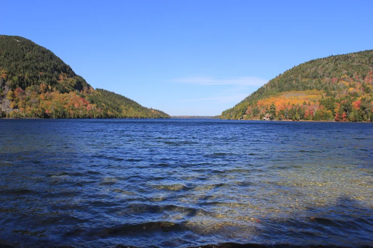 JORDAN POND. THE SOUND OF SOFT CLEAR WAVES TUMBLING OVER SMALL ROCKS BEFORE GREETING THE SHORE OF THE SMALL MOUNTAIN LAKE. ALSO KNOWN AS A TARN.