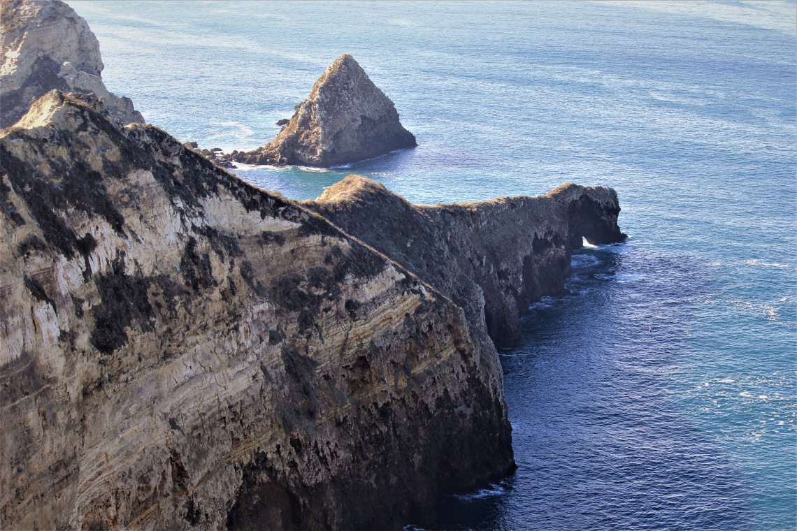 The southern wall of Potato Harbor. Near the end of the sloping rock, the sea has carved tunnels.